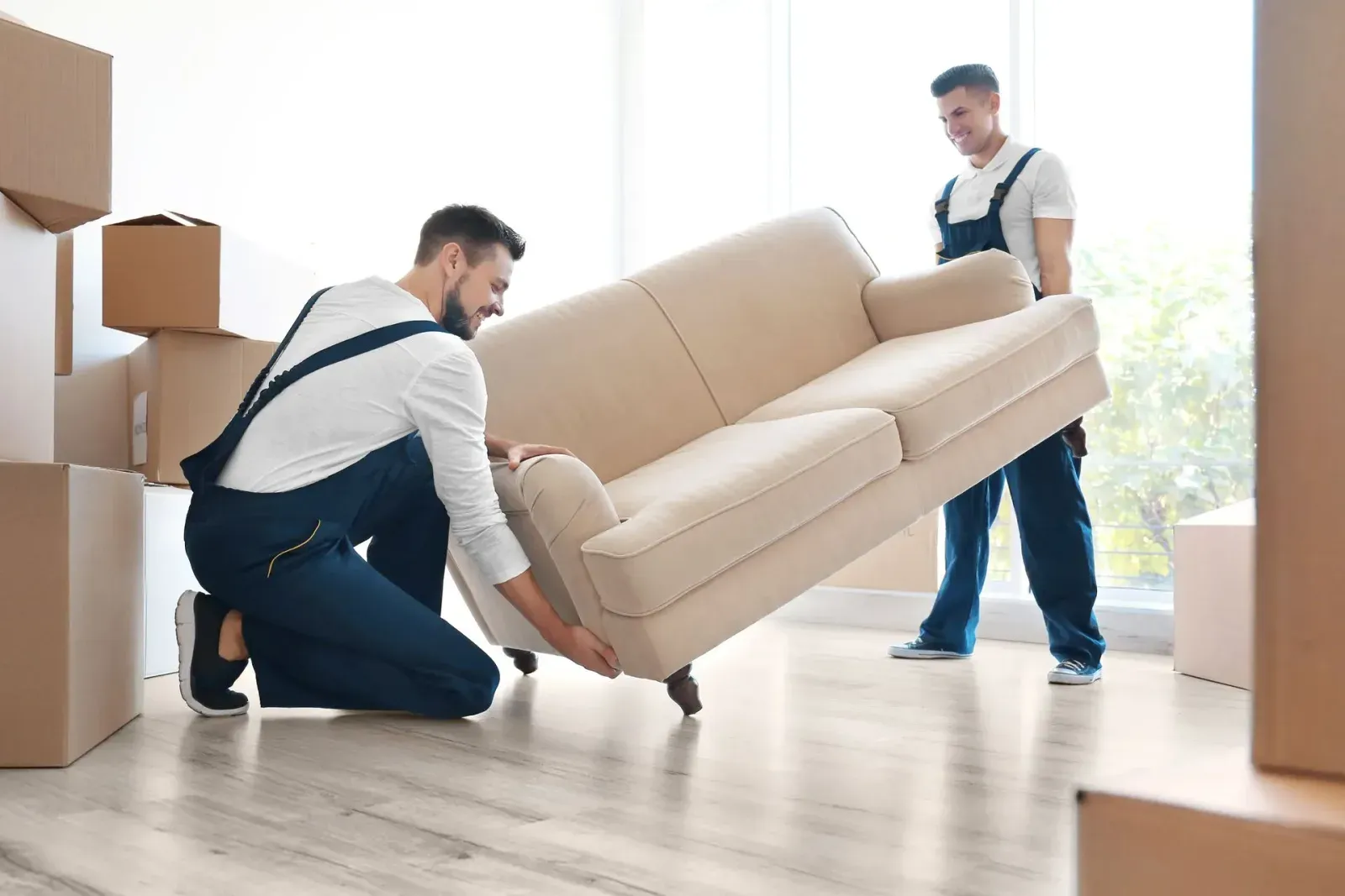 Zwei Umzugshelfer heben ein Sofa an