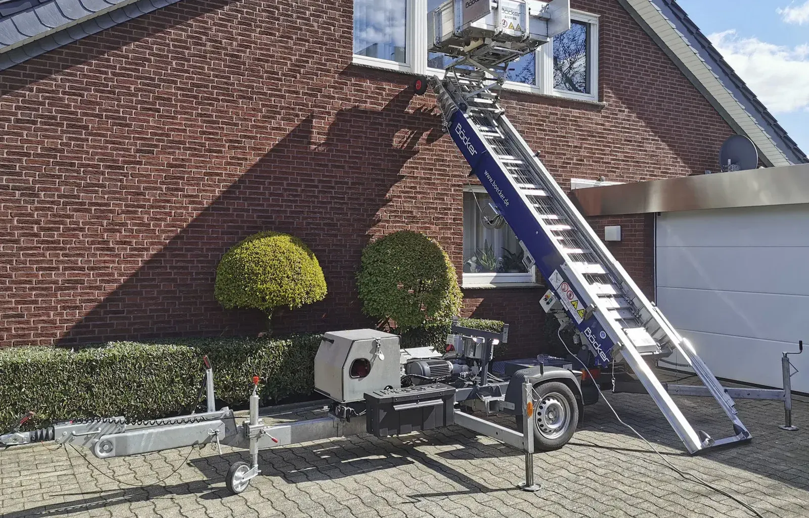 Möbellift an einem Klinkerhaus, Plattform am Fenster im Obergeschoss